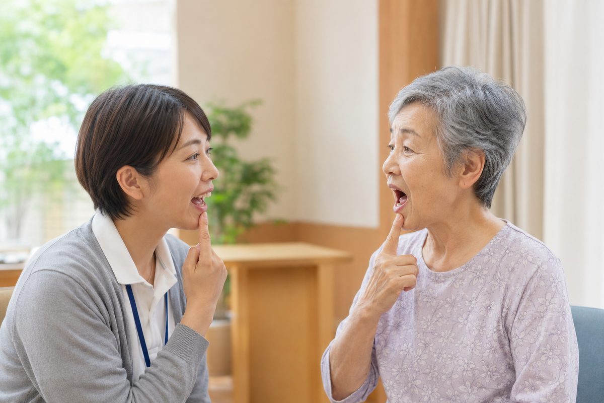 お口の動きを一緒に確認するご入居者様とスタッフ